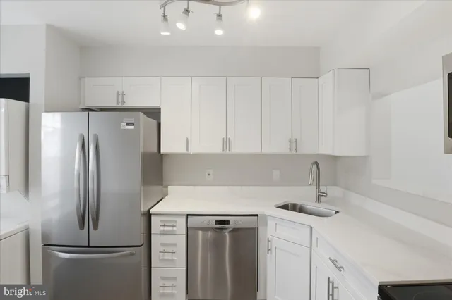 a kitchen with a refrigerator sink and cabinets