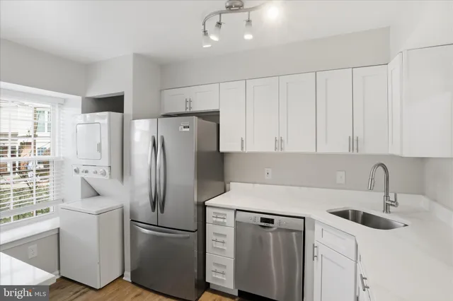 a kitchen with stainless steel appliances a refrigerator sink and cabinets