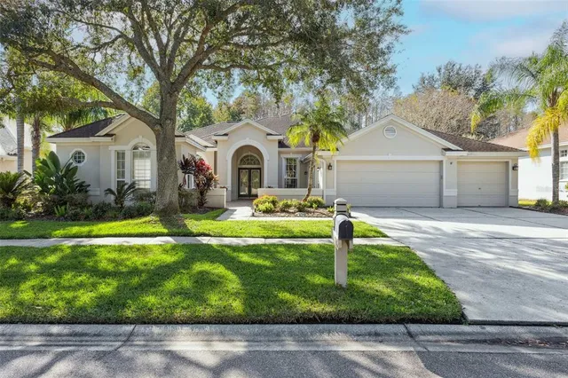 a front view of a house with garden and trees