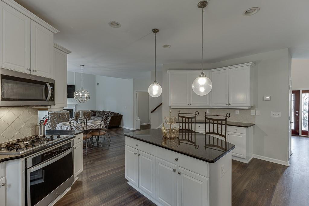 3265 Thimbleberry Trail Dacula, GA 30019 - Photo 12 of 61 a kitchen with stainless steel appliances granite countertop a stove a sink and a microwave