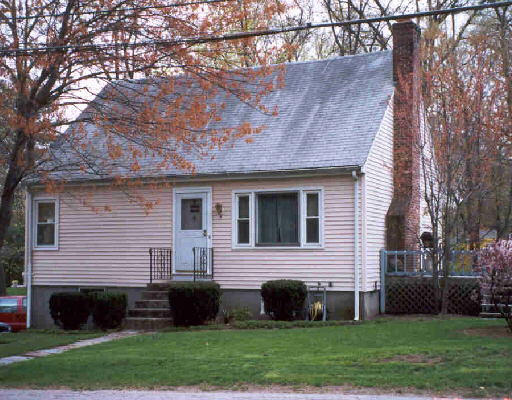 a front view of a house with a garden and yard