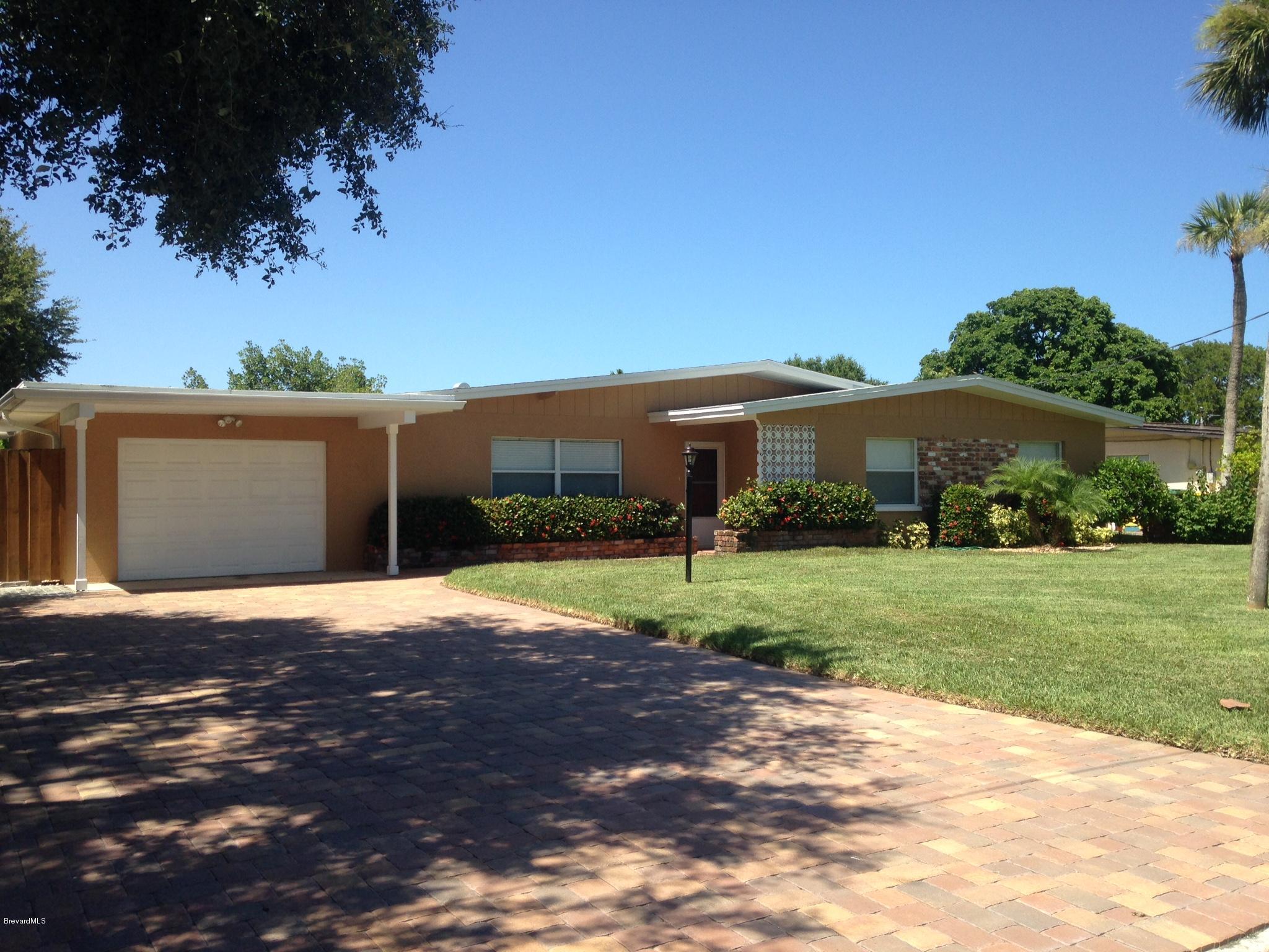 1025 Trinidad Road Cocoa Beach, FL 32931 - Photo 1 of 25 a front view of a house with a yard and garage