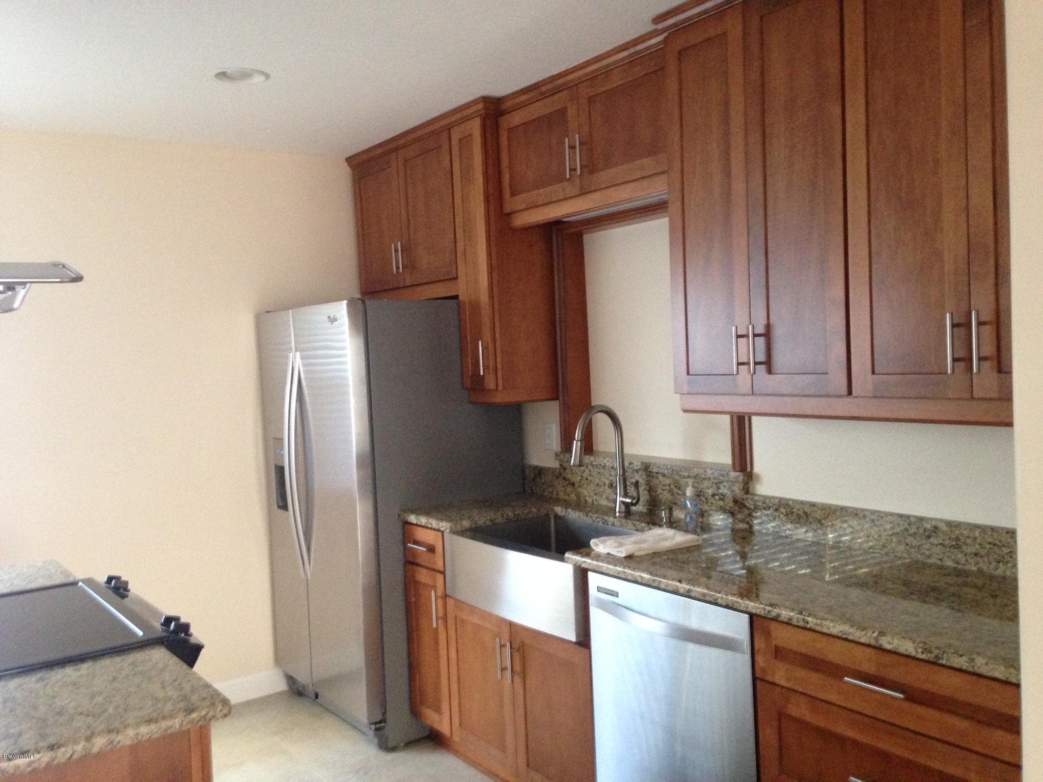 1025 Trinidad Road Cocoa Beach, FL 32931 - Photo 13 of 25 a kitchen with stainless steel appliances granite countertop a refrigerator and a sink