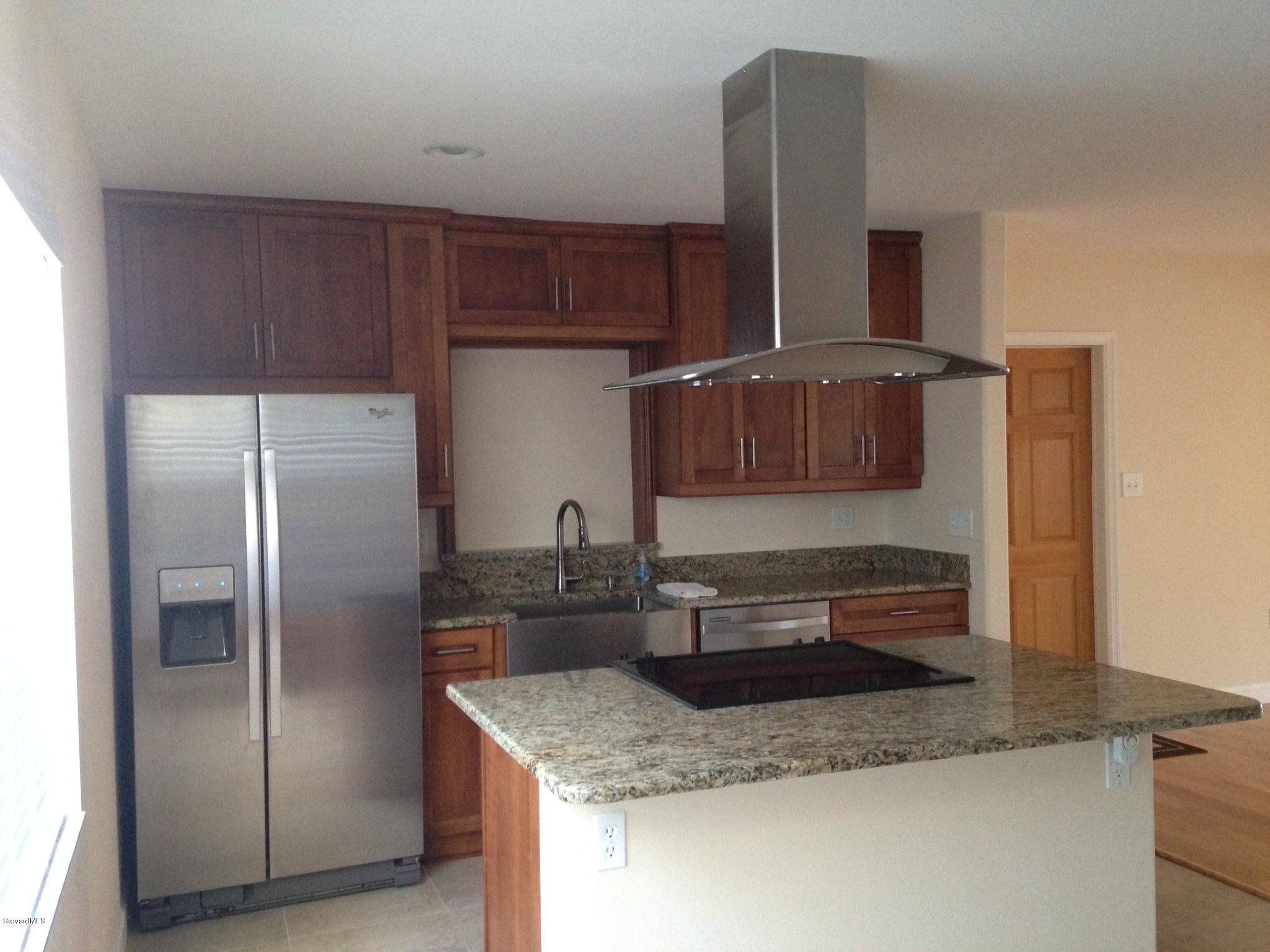 1025 Trinidad Road Cocoa Beach, FL 32931 - Photo 15 of 25 a kitchen with stainless steel appliances granite countertop a refrigerator and a sink