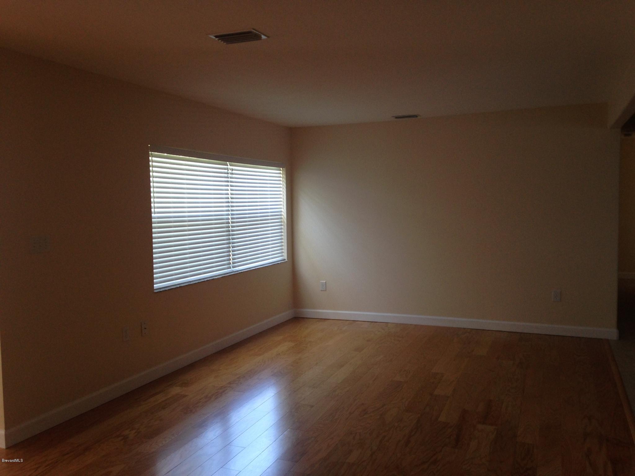 1025 Trinidad Road Cocoa Beach, FL 32931 - Photo 22 of 25 an empty room with wooden floor and windows