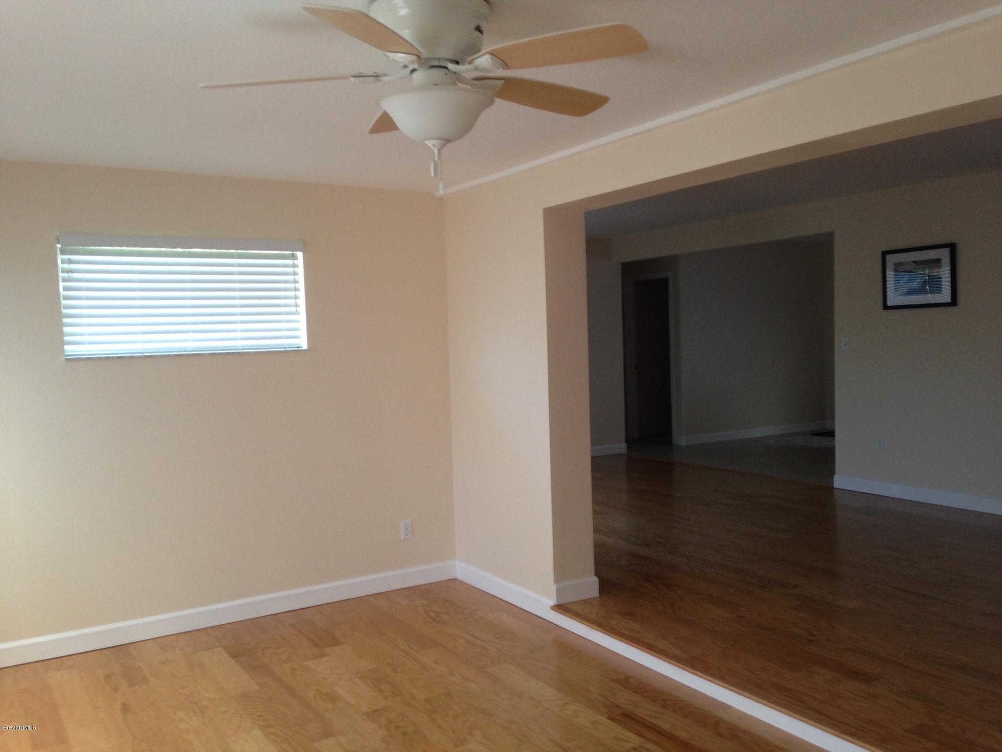 1025 Trinidad Road Cocoa Beach, FL 32931 - Photo 25 of 25 an empty room with wooden floor fan and windows