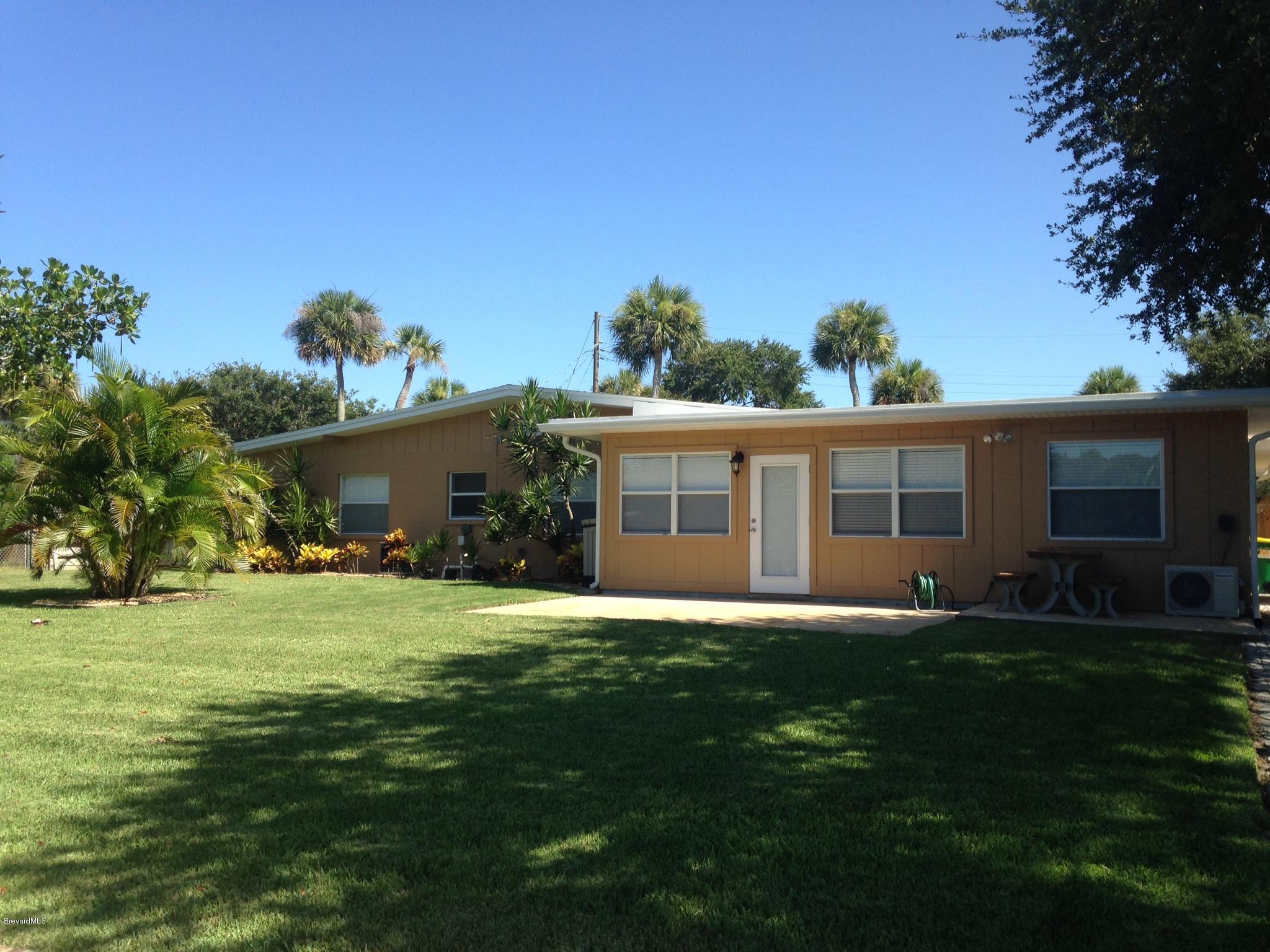 1025 Trinidad Road Cocoa Beach, FL 32931 - Photo 4 of 25 a front view of a house with a garden and yard