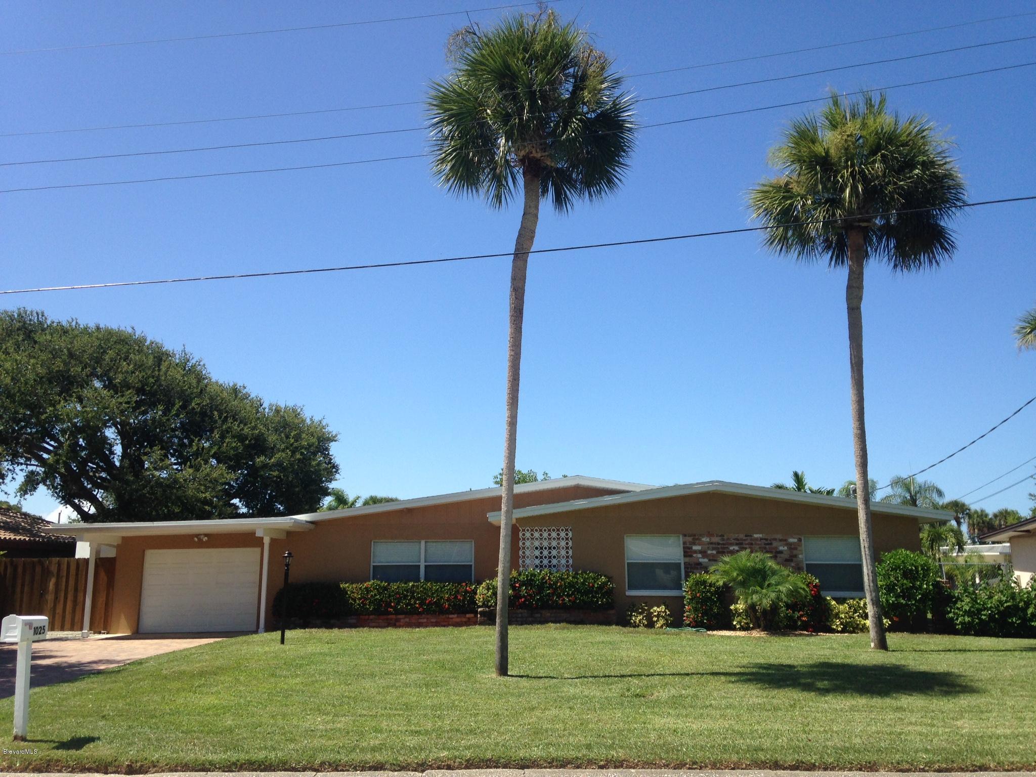 1025 Trinidad Road Cocoa Beach, FL 32931 - Photo 6 of 25 a palm tree sitting in front of a house with a yard