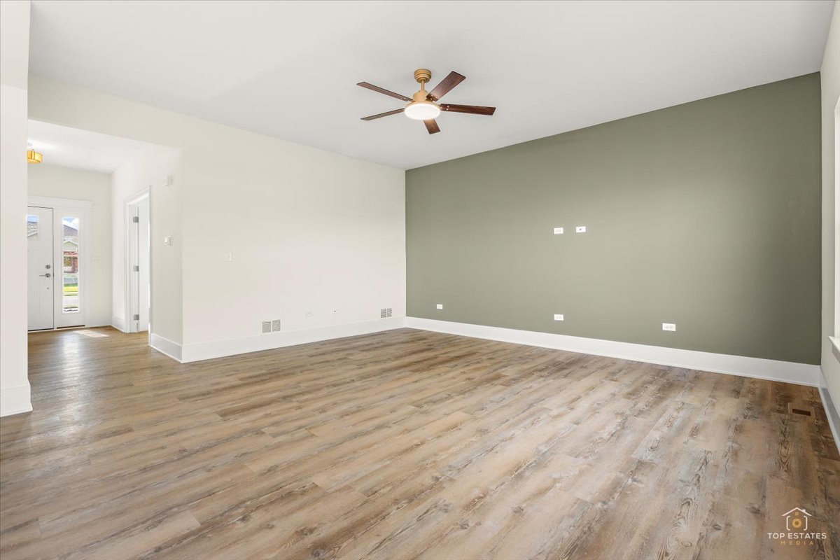 435 South Calkey Street Diamond, IL 60416 - Photo 8 of 31 an empty room with wooden floor and ceiling fan