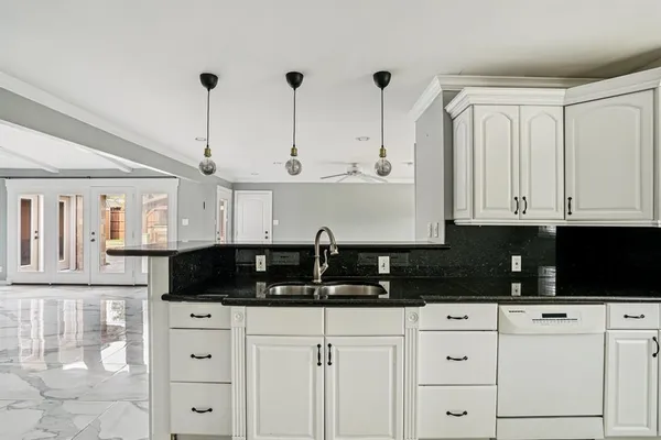 a kitchen with stainless steel appliances granite countertop white cabinets and black granite counter tops
