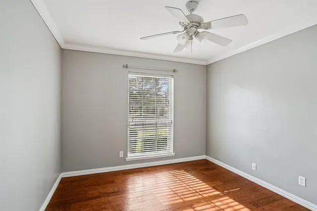 a view of an empty room with window and a chandelier fan