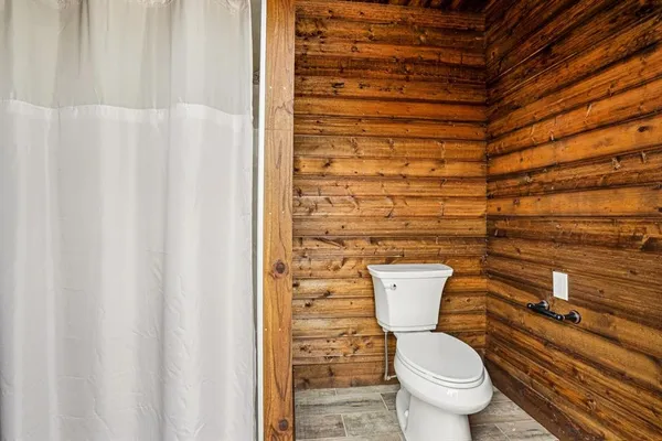 a bathroom with a toilet and a shower curtain
