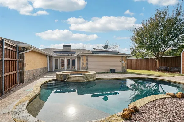 a front view of a house with swimming pool and furniture