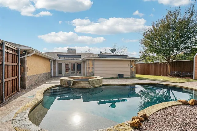 a front view of a house with swimming pool and furniture