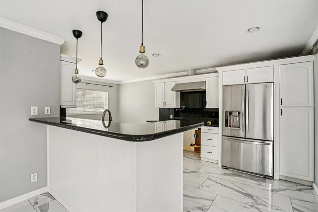 a kitchen with stainless steel appliances granite countertop a sink and a refrigerator
