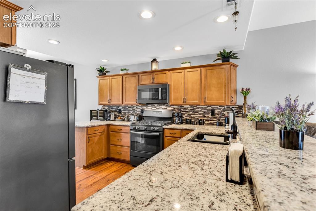 415 Empire Road Canon City, CO 81212 - Photo 14 of 40 a kitchen with stainless steel appliances kitchen island granite countertop a sink stove and refrigerator