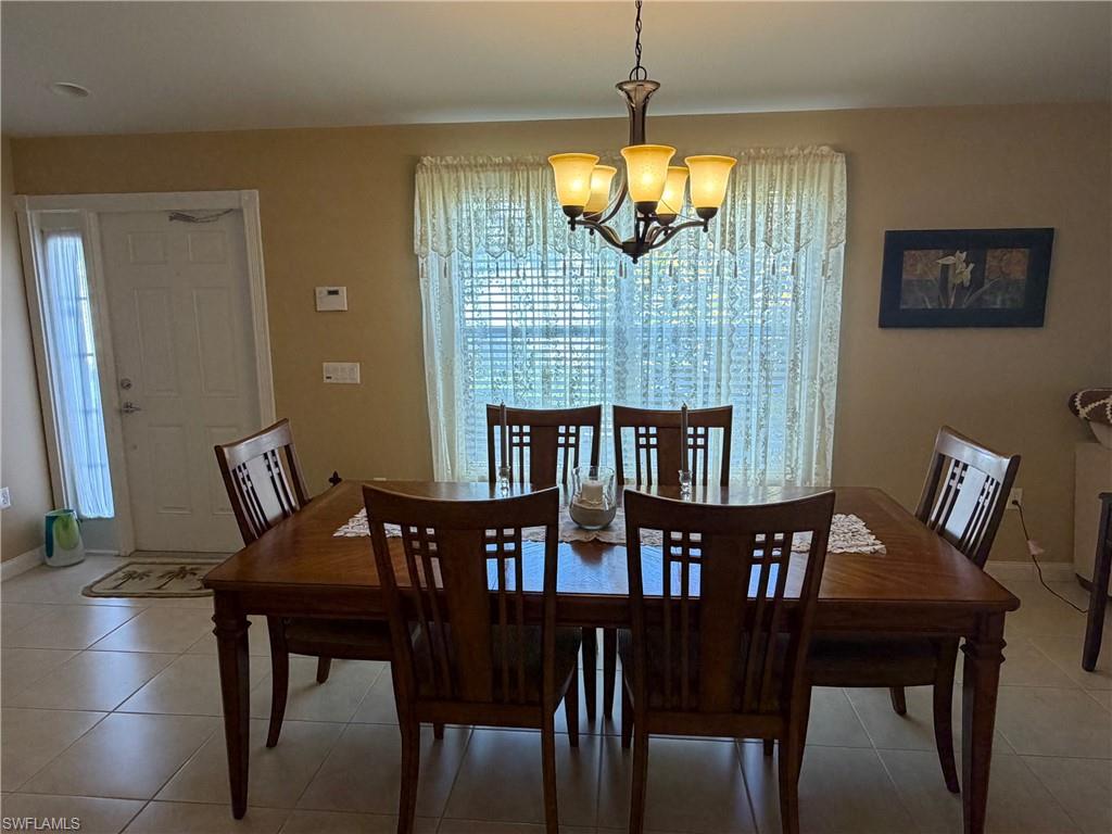 7264 Salerno Court Naples, FL 34114 - Photo 11 of 45 Dining space with a chandelier and light tile patterned flooring