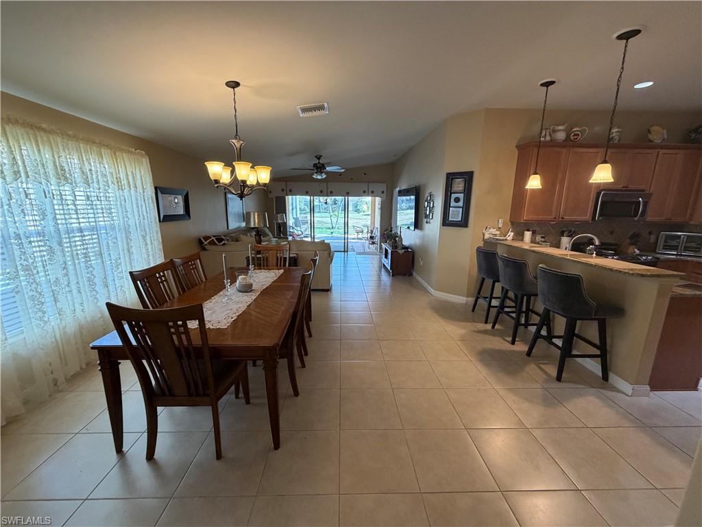 7264 Salerno Court Naples, FL 34114 - Photo 12 of 45 Dining space with ceiling fan, light tile patterned flooring, a chandelier, recessed lighting, and vaulted ceiling