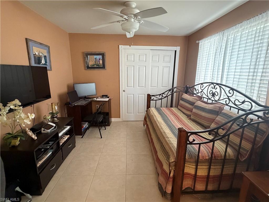 7264 Salerno Court Naples, FL 34114 - Photo 20 of 45 Bedroom featuring light tile patterned floors, a closet, ceiling fan, and an office area