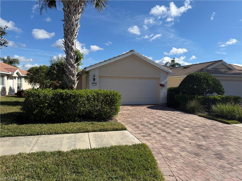 7264 Salerno Court Naples, FL 34114 - Photo 2 of 45 Ranch-style home featuring stucco siding, decorative driveway, and a garage