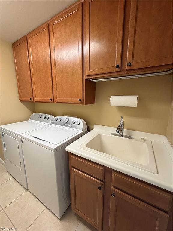7264 Salerno Court Naples, FL 34114 - Photo 24 of 45 Laundry area featuring washing machine and dryer, cabinet space, and light tile patterned floors