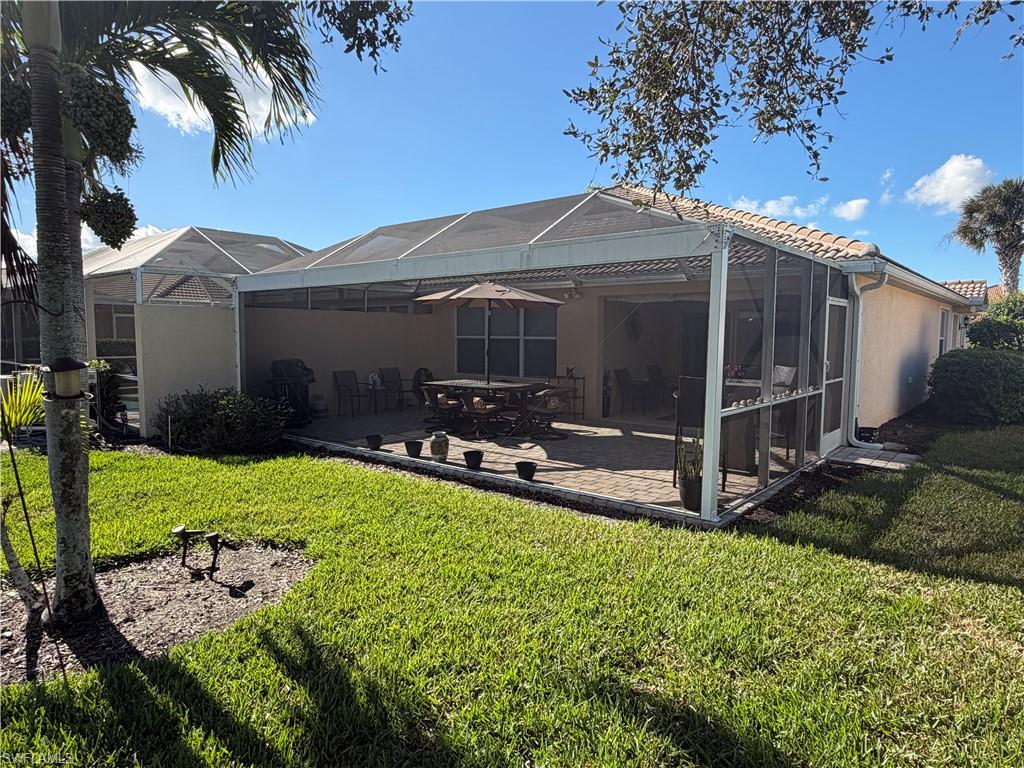 7264 Salerno Court Naples, FL 34114 - Photo 27 of 45 Rear view of property with a lanai, a sunroom, a lawn, and a patio area