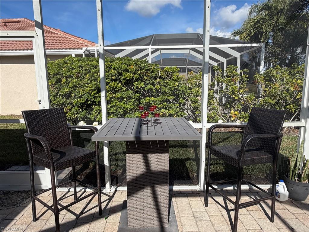 7264 Salerno Court Naples, FL 34114 - Photo 36 of 45 View of patio / terrace featuring glass enclosure, a sunroom, and outdoor dining area