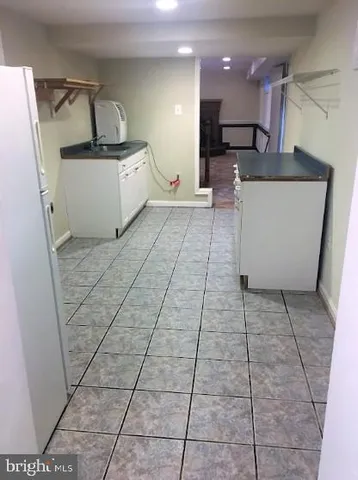 a large white kitchen with a stove a sink and a refrigerator