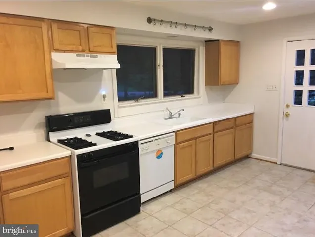 a kitchen with stainless steel appliances a stove a sink and a microwave