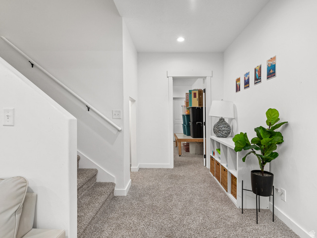 627 South Meade Street Mapleton, UT 84664 - Photo 22 of 48 Carpeted hallway featuring a staircase with a white handrail, recessed lighting, and a doorway to an interior space