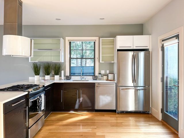 a kitchen with stainless steel appliances granite countertop a refrigerator sink and wooden floor