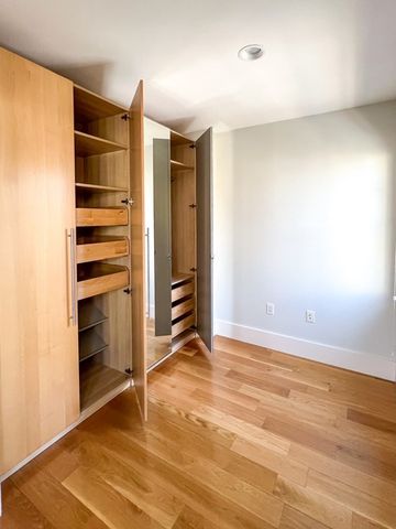 a view of an empty room with closet and a window