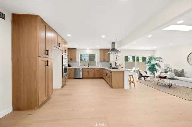 a large white kitchen with a refrigerator a stove a dining table and chairs