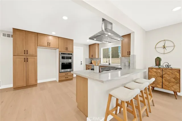 a kitchen with stainless steel appliances granite countertop a stove a sink and white cabinets