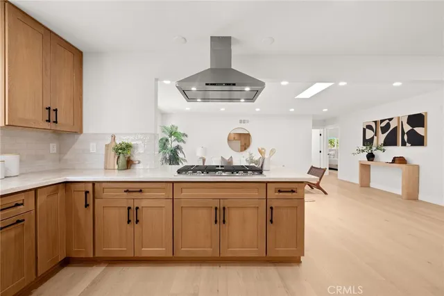 a kitchen with granite countertop a stove a sink and white cabinets