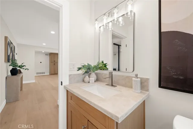 a bathroom with a granite countertop sink mirror vanity toilet and bathtub