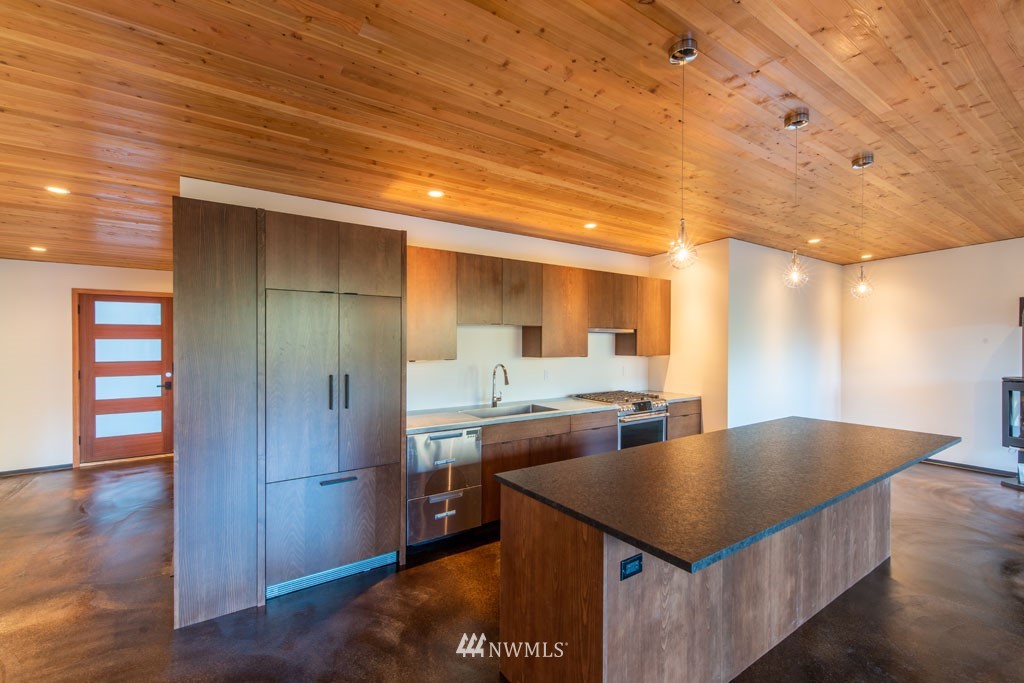 39 Bitterbrush Road Winthrop, WA 98862 - Photo 16 of 40 a kitchen with stainless steel appliances granite countertop a sink a microwave cabinets and wooden floor