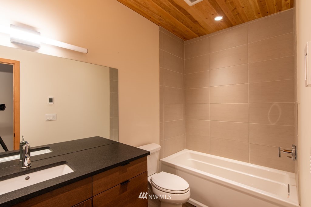 39 Bitterbrush Road Winthrop, WA 98862 - Photo 23 of 40 a bathroom with a granite countertop sink toilet a mirror and shower