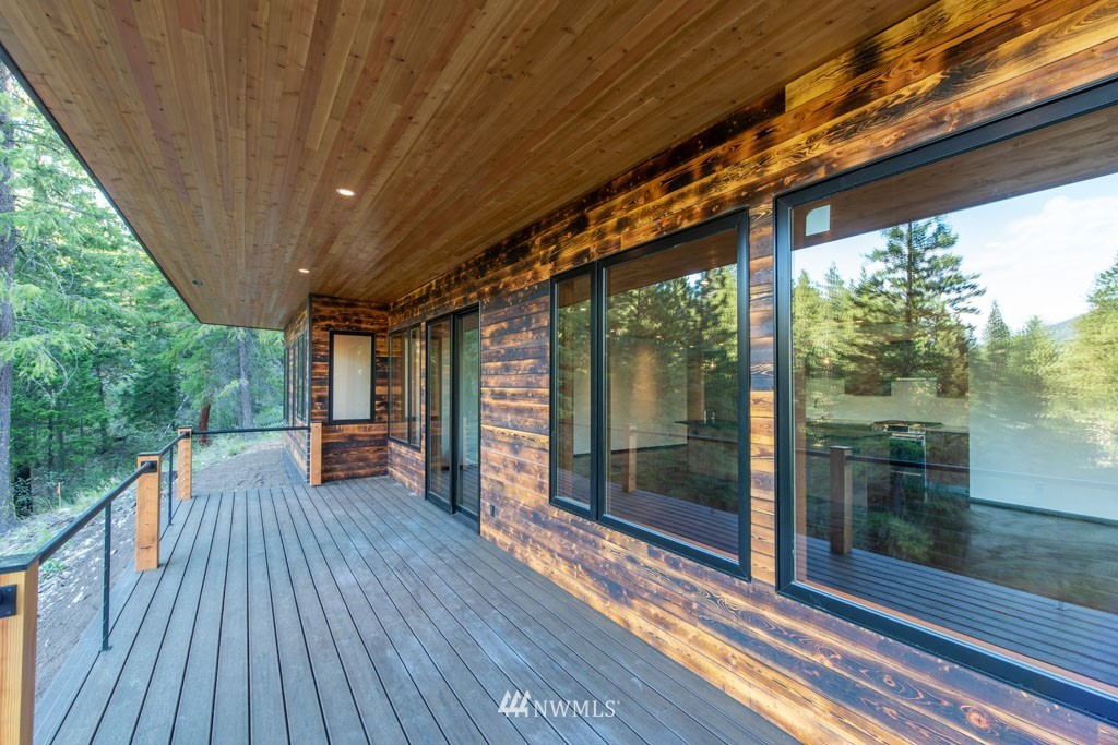 39 Bitterbrush Road Winthrop, WA 98862 - Photo 27 of 40 a porch with wooden floor outdoor seating and yard in the back