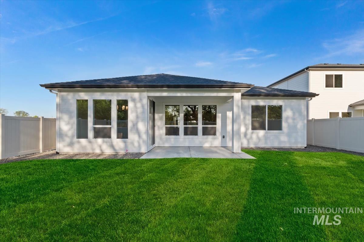 3321 Helios Street Caldwell, ID 83607 - Photo 34 of 35 Expansive backyard featuring a manicured lawn, a concrete patio, and a white privacy fence