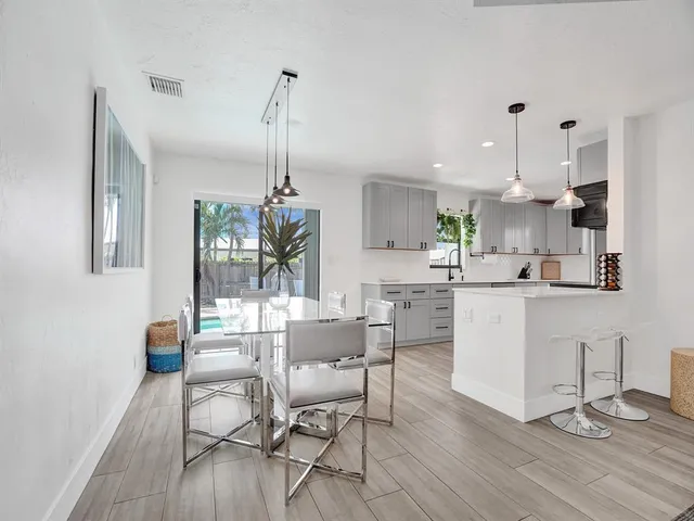 a dining room with kitchen island stainless steel appliances furniture a dining table and chairs
