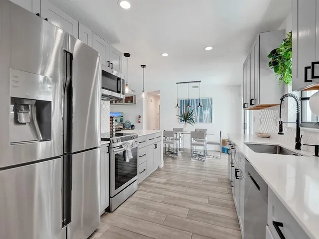 a kitchen with stainless steel appliances a refrigerator sink and microwave