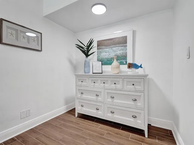 a room with painting on the wall and a dresser