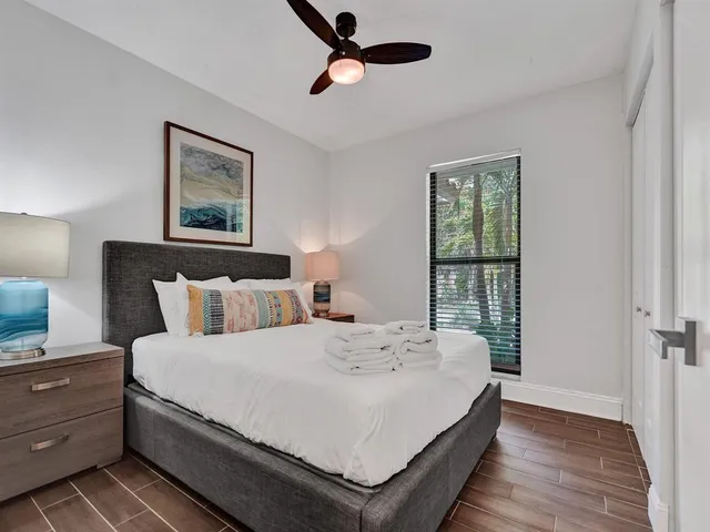 a large bedroom with a bed and wooden floor