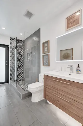 a bathroom with a toilet sink vanity and mirror