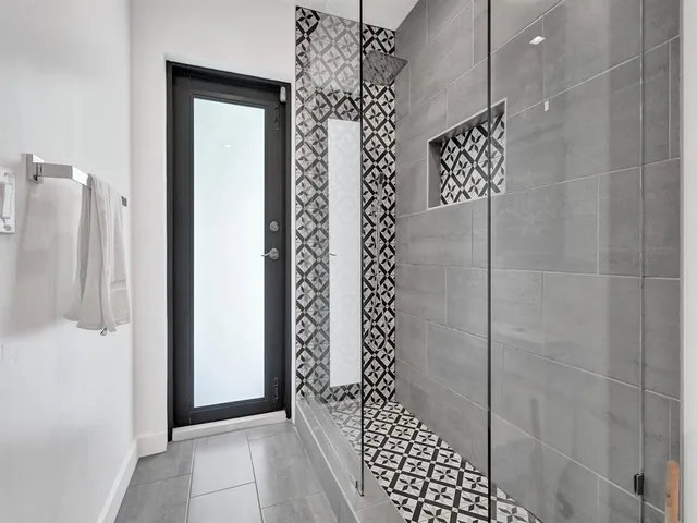 a large bed in a white room with closet and chandelier