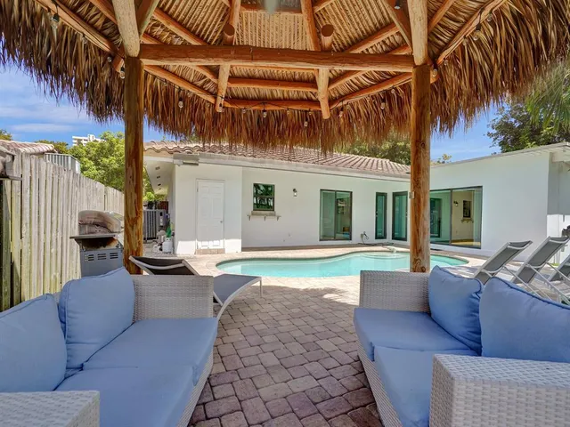 a view of a backyard with table and chairs with wooden fence and plants