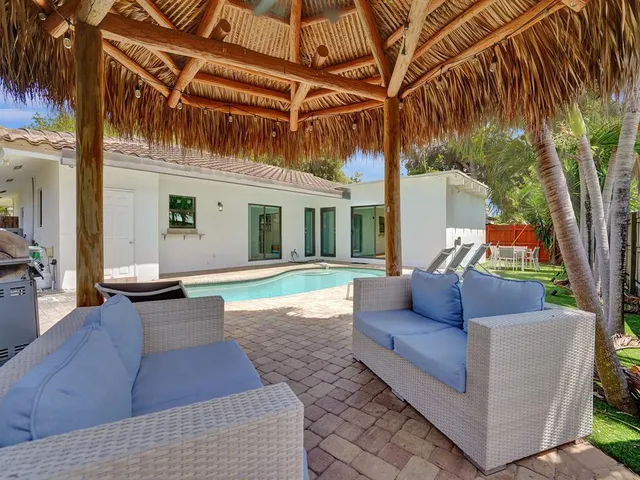 a patio with table and chairs and potted plants