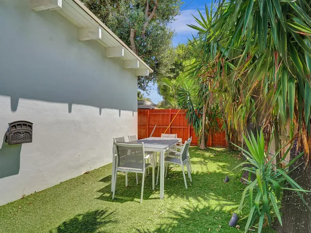 a front view of a house with garden and trees