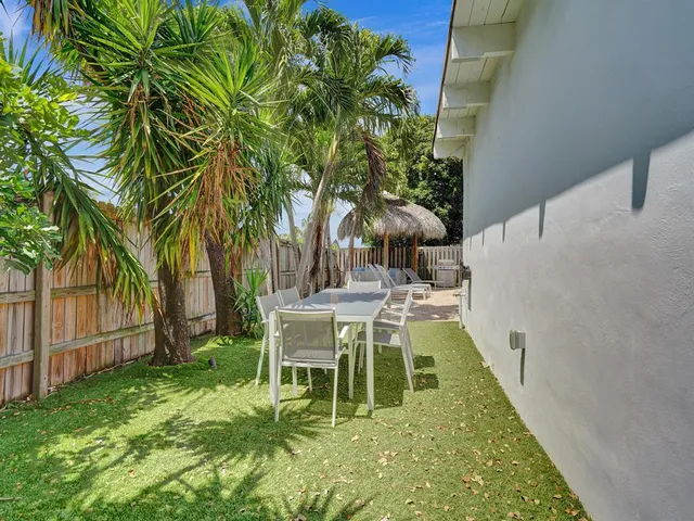 a view of a chair and table in the back yard of a house